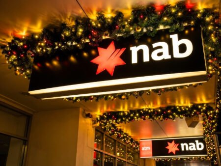 NAB Plans 2,500 Job Cuts Amid AI Concerns National Australia Bank signage outside a bank branch in Australia.